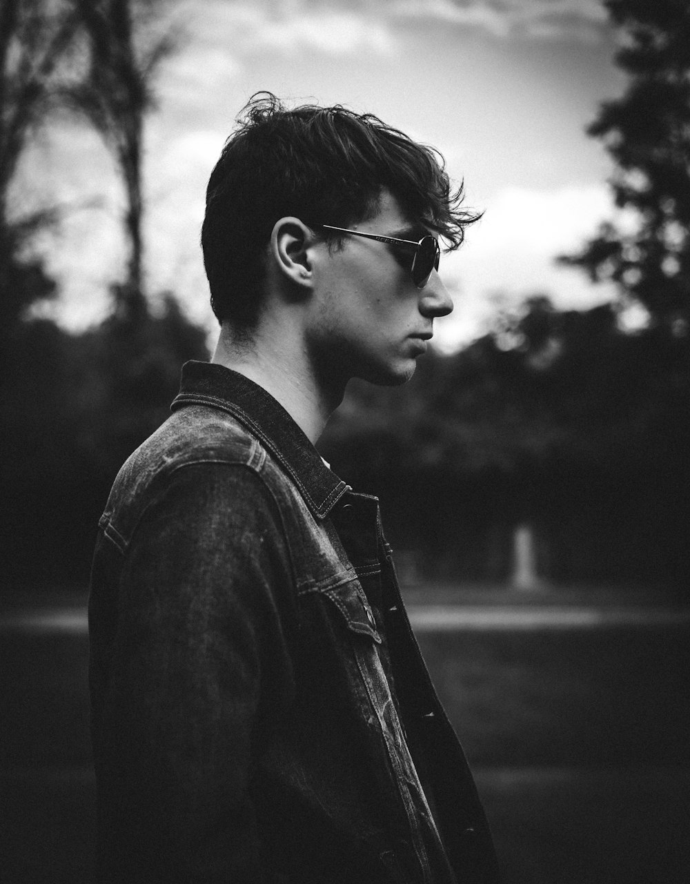 a young man wearing sunglasses and a denim jacket