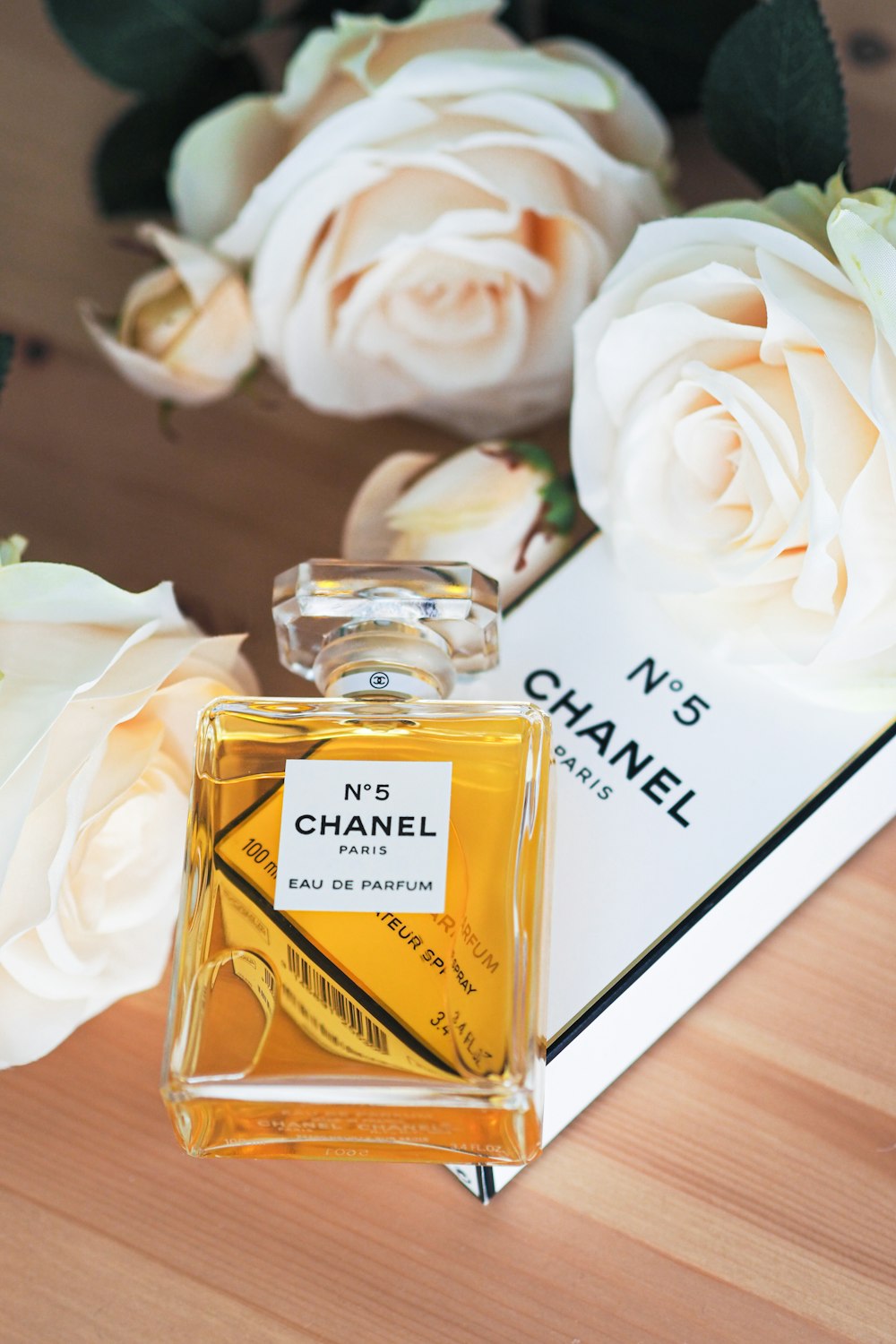 A bottle of chanel no 5 next to flowers photo – Free Bottle Image on  Unsplash