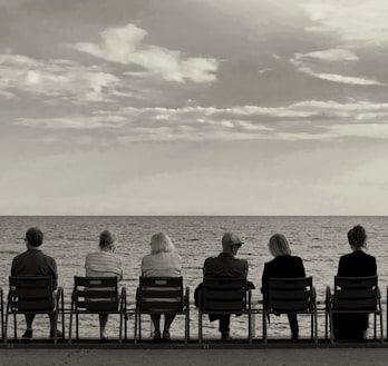 a group of people sitting on top of a beach next to the ocean