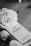 A black and white image features a perfume box labeled No. 5 Chanel Paris surrounded by elegant roses. The luxurious aesthetic is highlighted by the classic and timeless brand presentation.