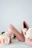 Close-up of a pair of elegant blush pink heels resting on a soft beige fabric background.
