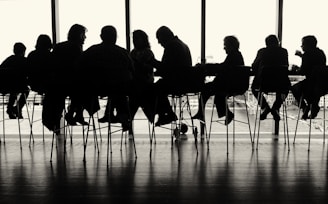a group of people sitting at a table in front of a window