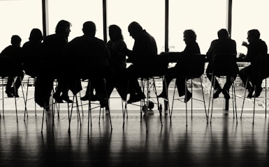 a group of people sitting at a table in front of a window