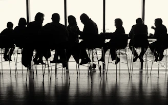 a group of people sitting at a table in front of a window