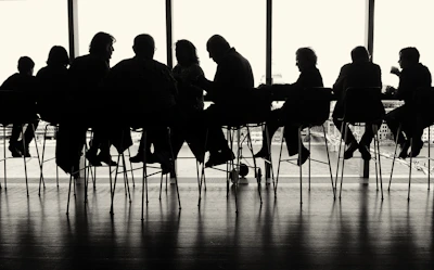a group of people sitting at a table in front of a window