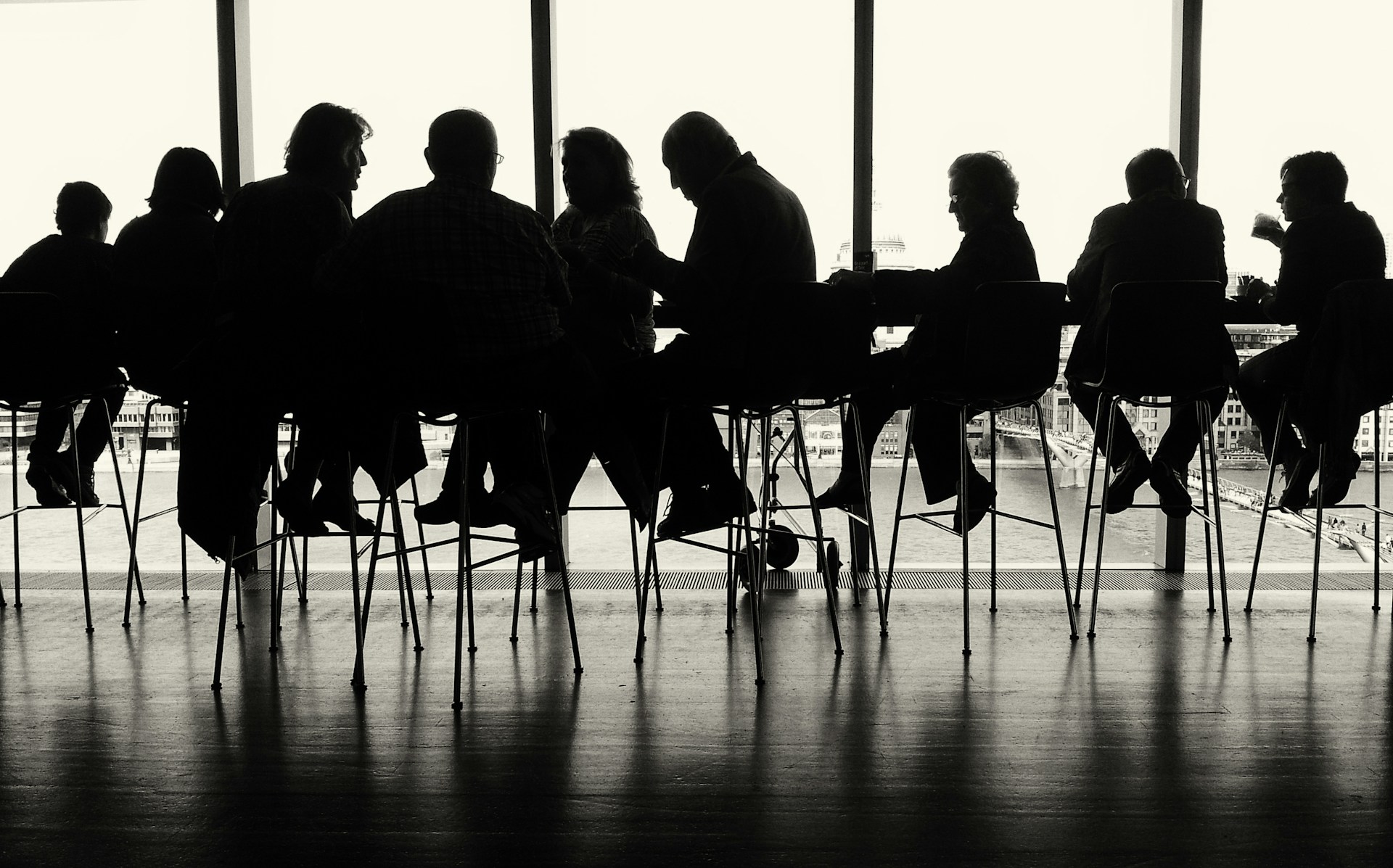 a group of people sitting at a table in front of a window