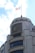 A large, elegant building with a prominent logo, featuring modern architecture and a rooftop proudly displaying a national flag.