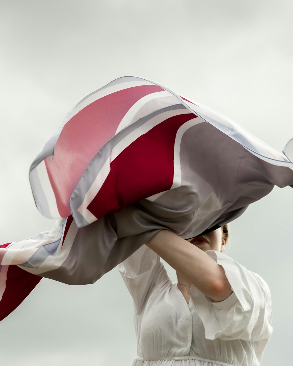 uma mulher em um vestido branco está segurando uma bandeira