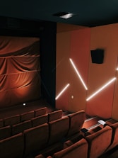 a theater with a row of seats and a projector screen