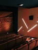 a theater with a row of seats and a projector screen