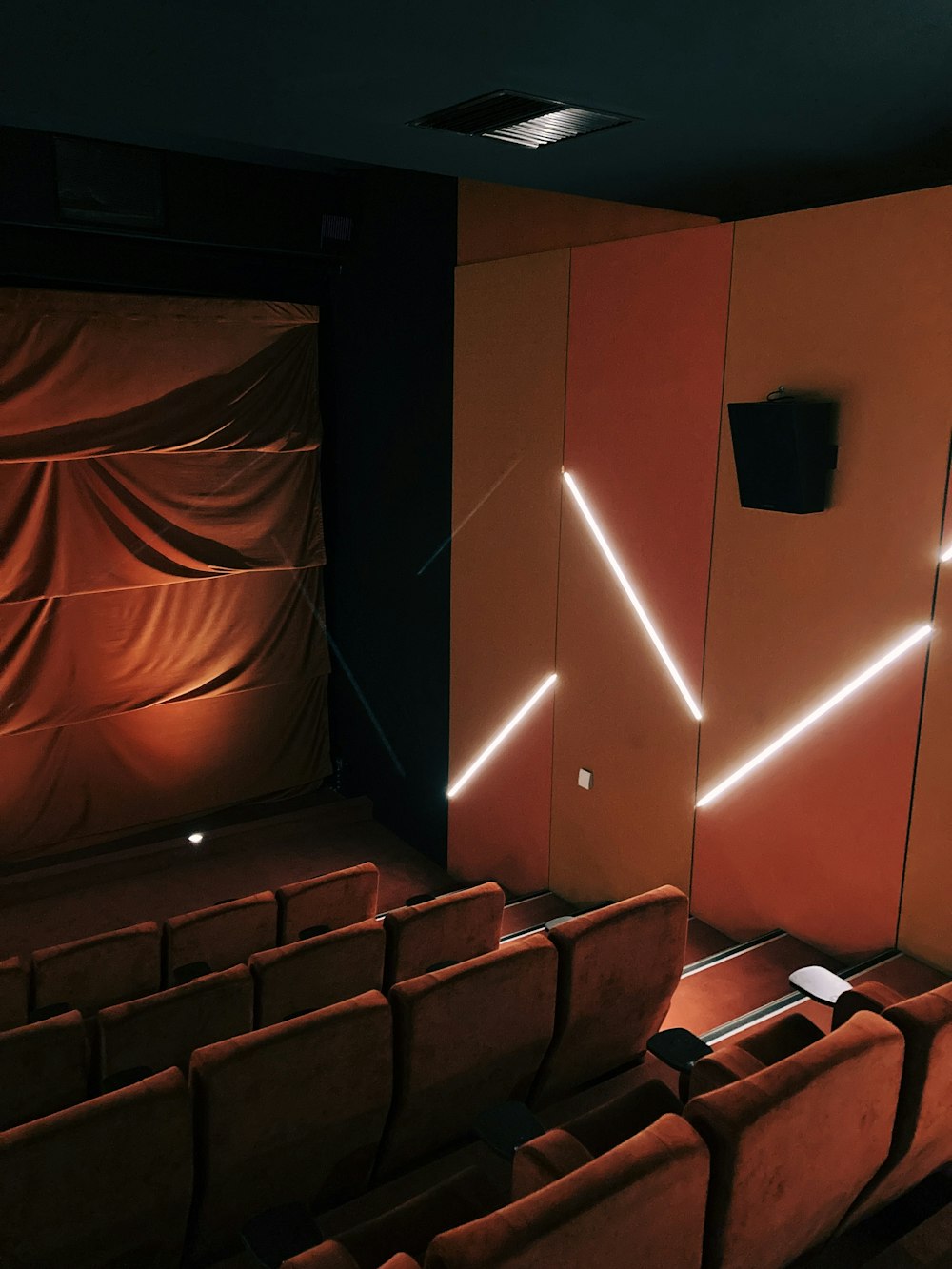 um teatro com uma fileira de assentos e uma tela de projetor