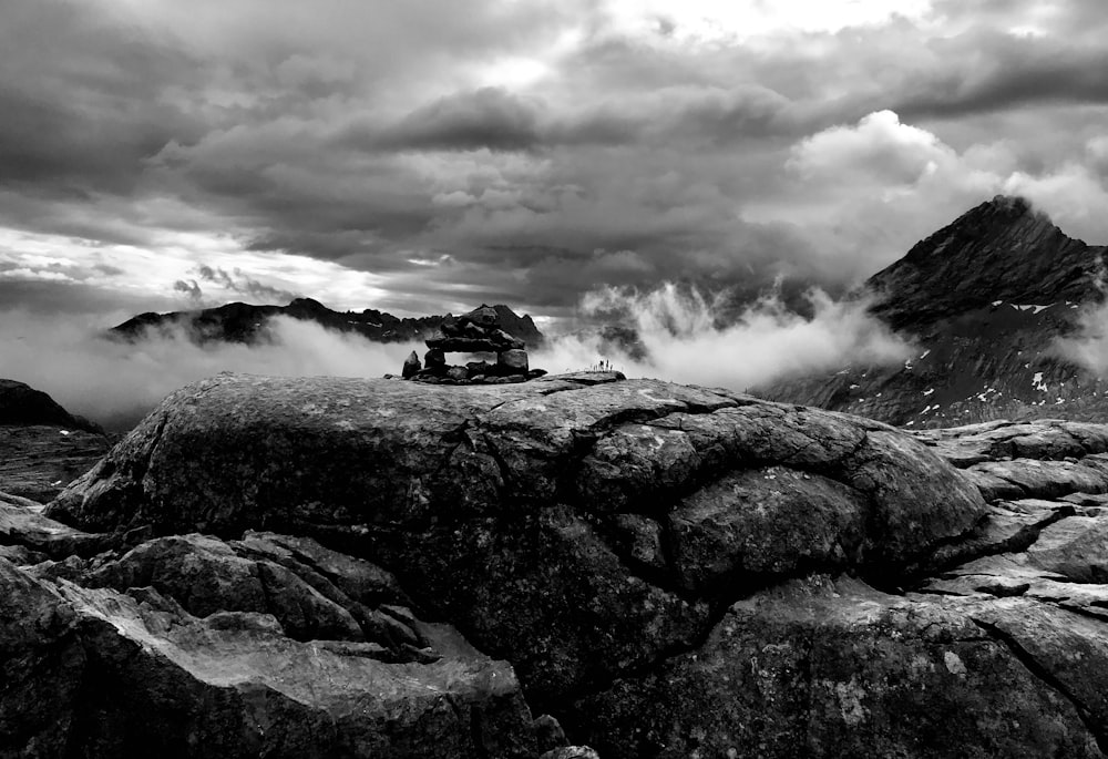 a black and white photo of a car on a rocky mountain