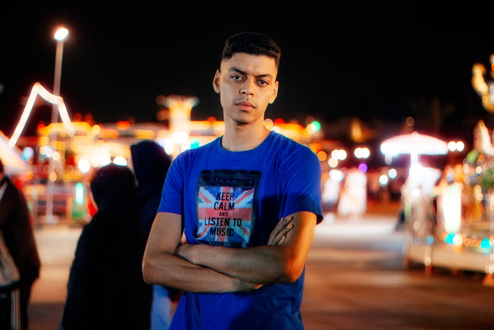 a man standing in front of a carnival at night