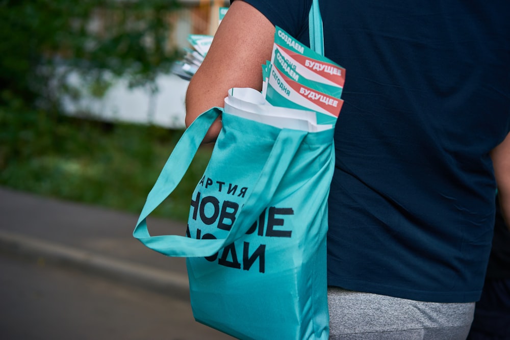 a person carrying a blue bag on the street