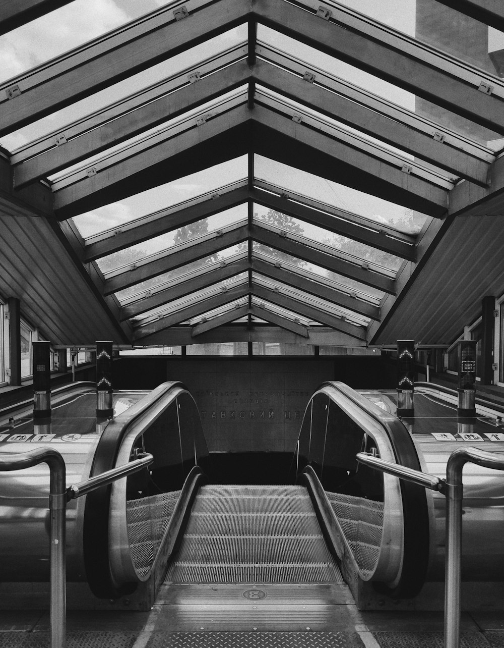 a black and white photo of an escalator