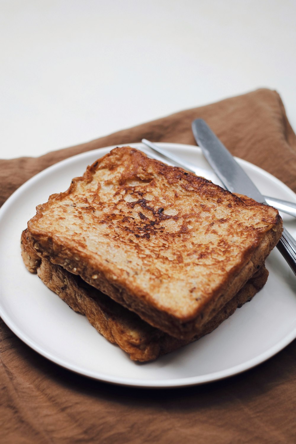 a grilled cheese sandwich on a plate with a fork