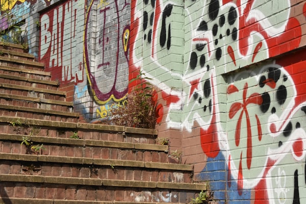outdoor brick stairs against a wall covered in heavy graffiti