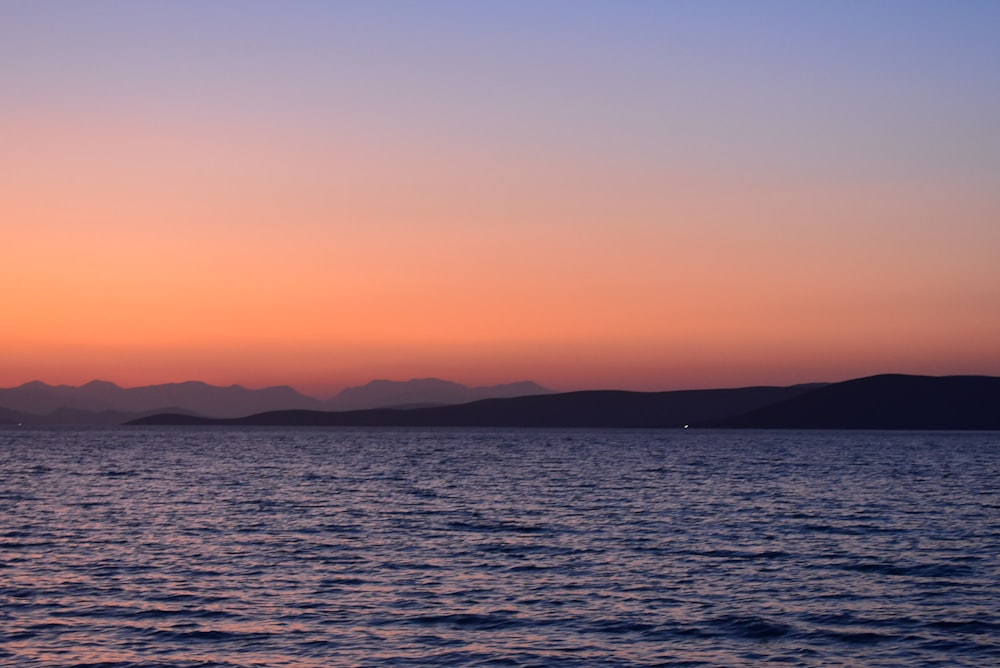 a large body of water with mountains in the background