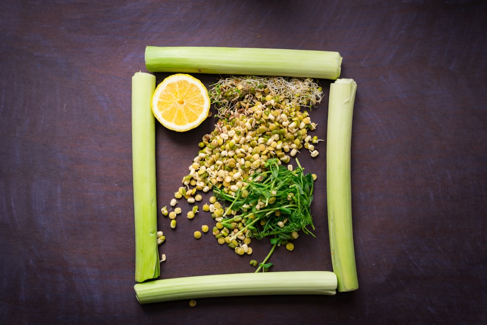a cutting board with celery, corn, and a lemon