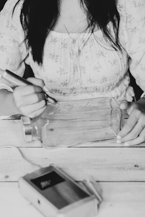 a woman sitting at a table writing on a piece of paper