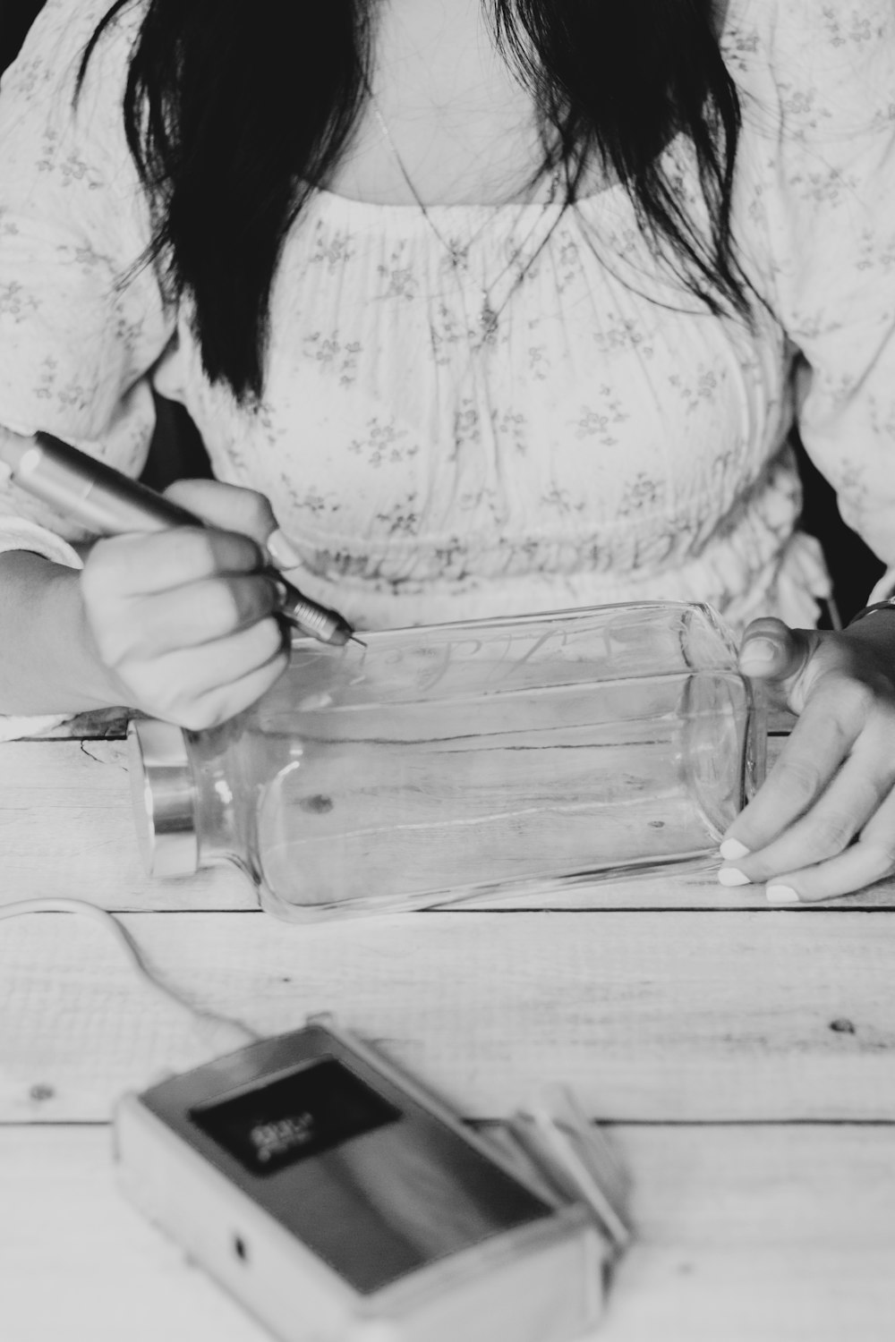 a woman sitting at a table writing on a piece of paper