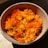 a bowl filled with orange flowers on top of a wooden table