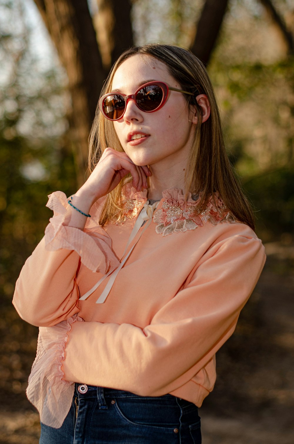 a woman wearing a pink shirt and sunglasses