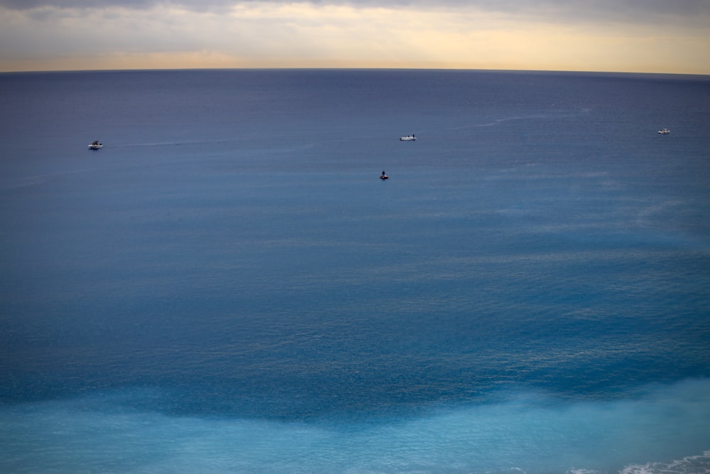 Un grupo de barcos flotando sobre una gran masa de agua