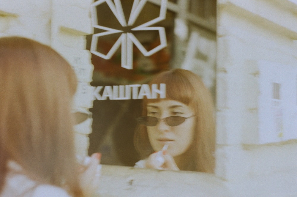 a woman is looking in the window of a store