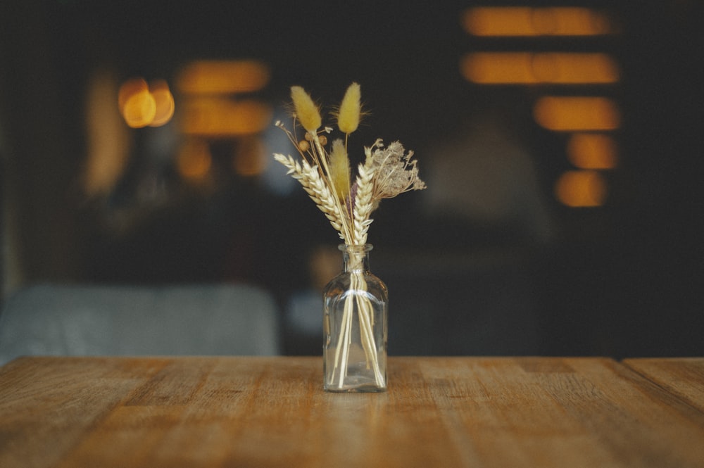 um vaso de flores sentado em cima de uma mesa de madeira