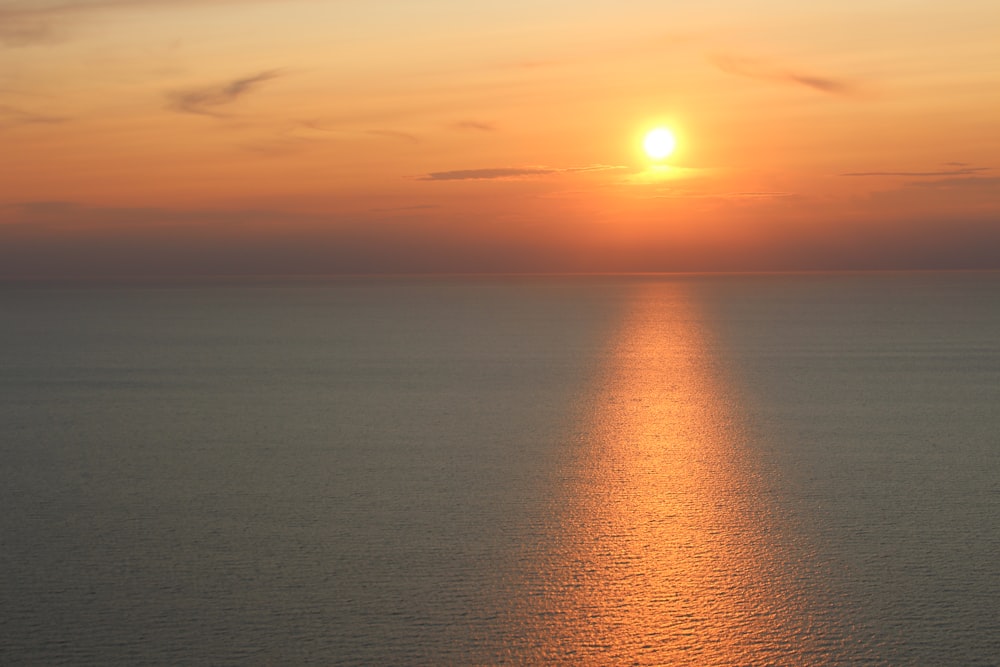 the sun is setting over the ocean on a clear day