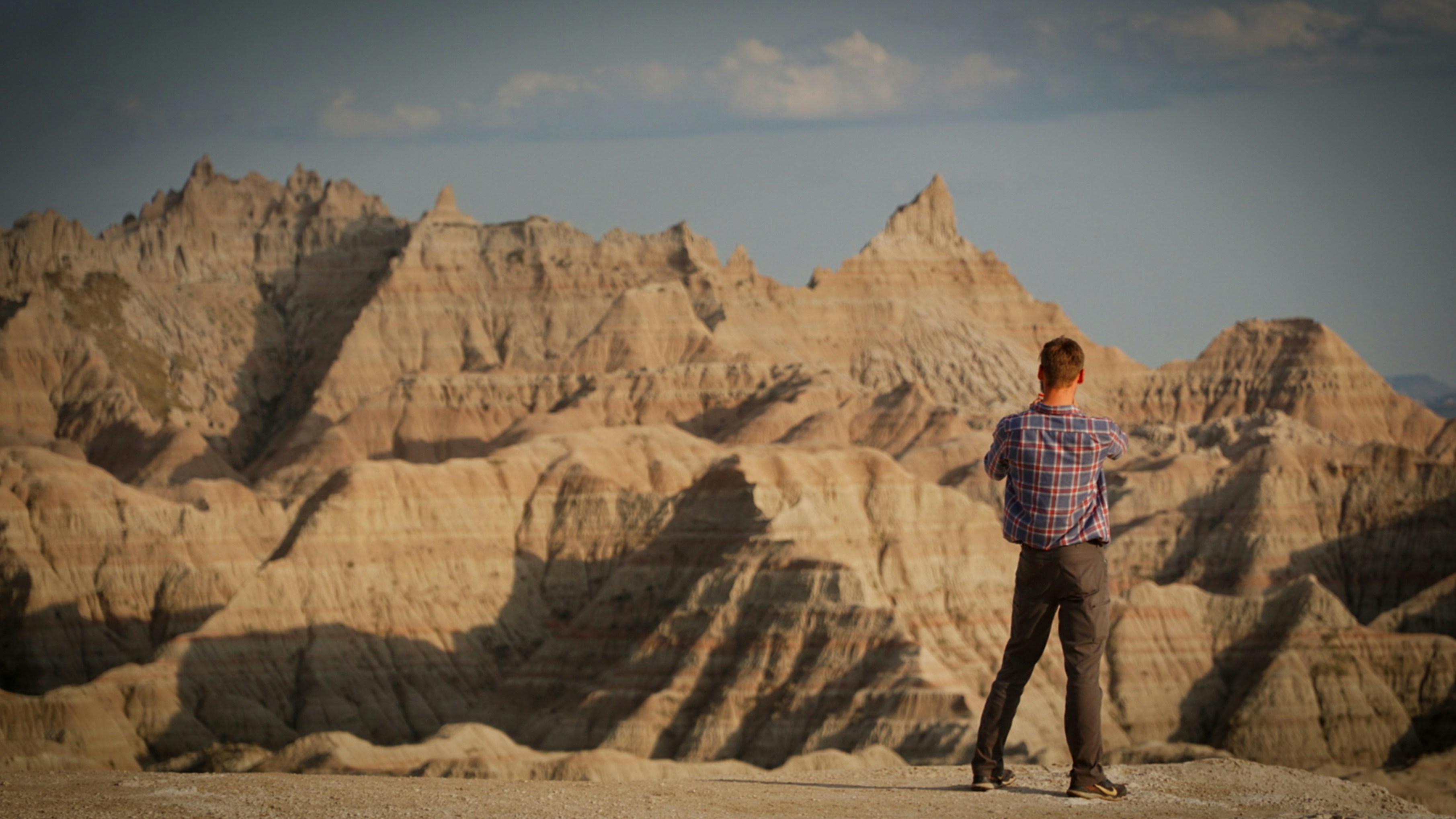 a man standing on top of a mountain looking at the mountains, 