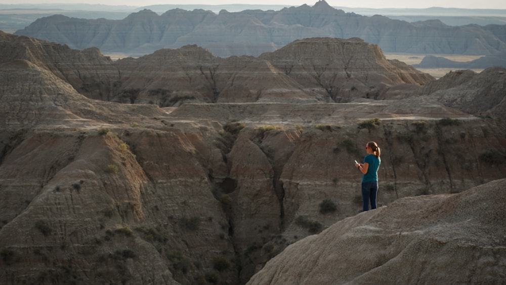 a person standing on top of a large rock