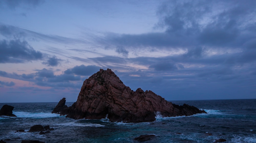 a large rock in the middle of the ocean