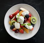a white plate topped with fruit and whipped cream