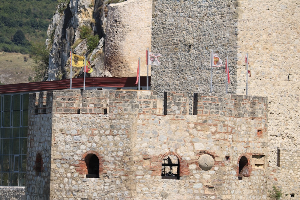 a stone castle with flags on top of it