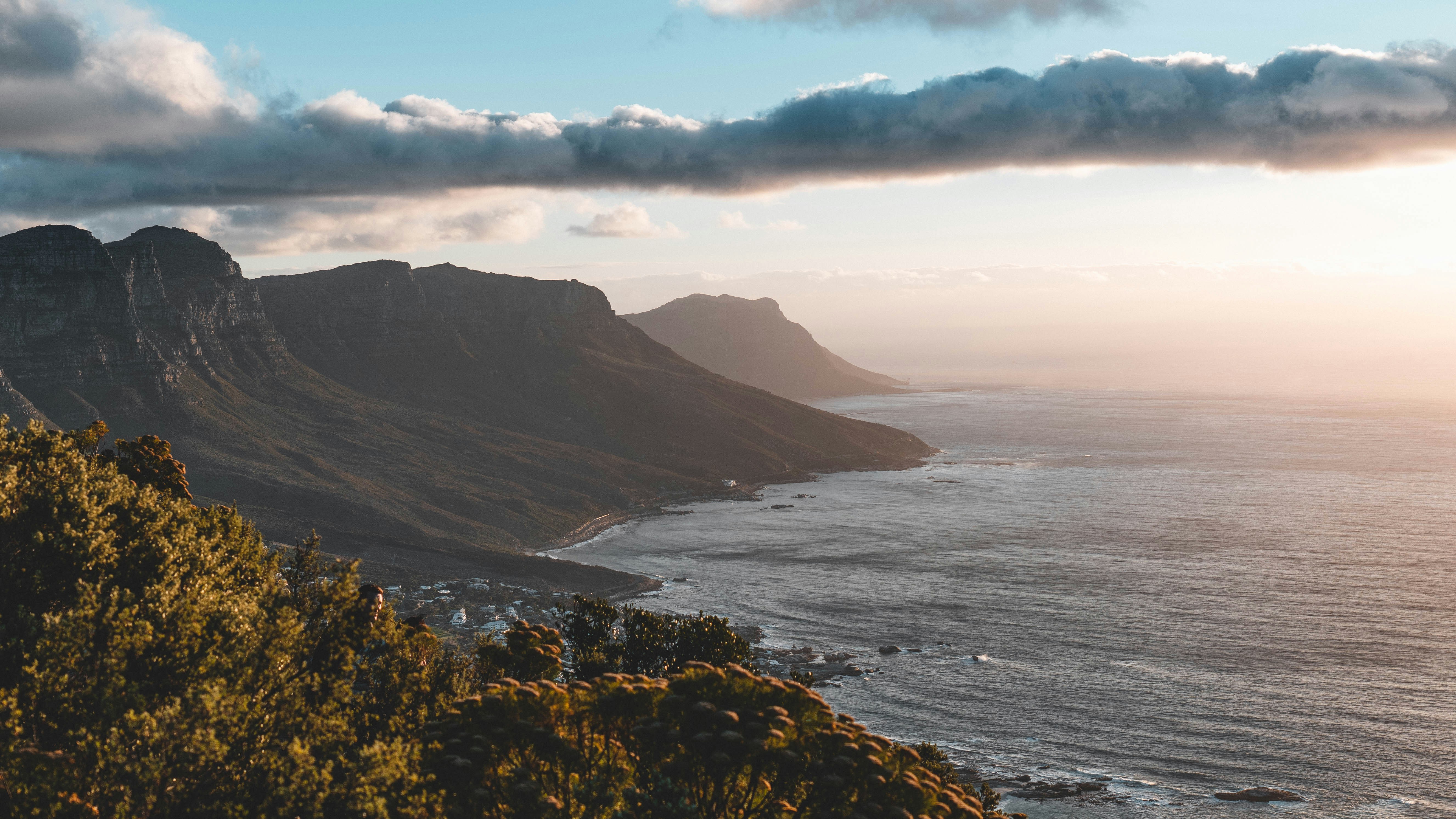 a scenic view of the ocean with mountains in the background