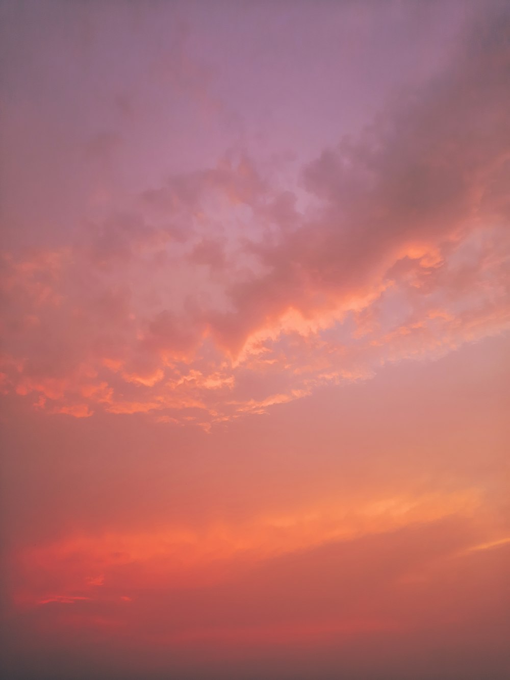 a plane flying in the sky at sunset