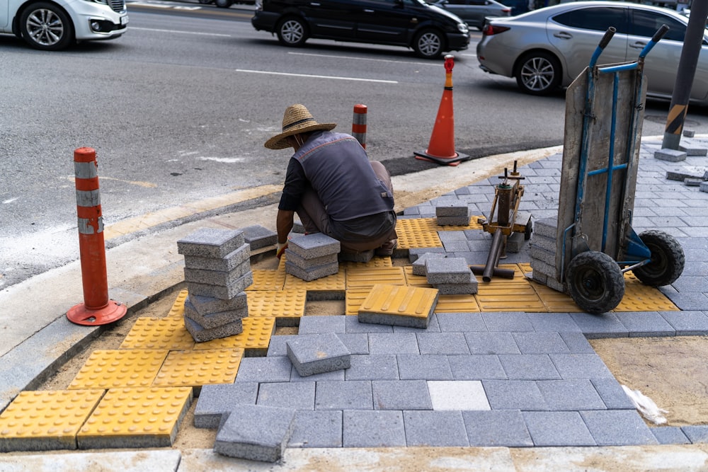 a man kneeling down next to a pile of blocks