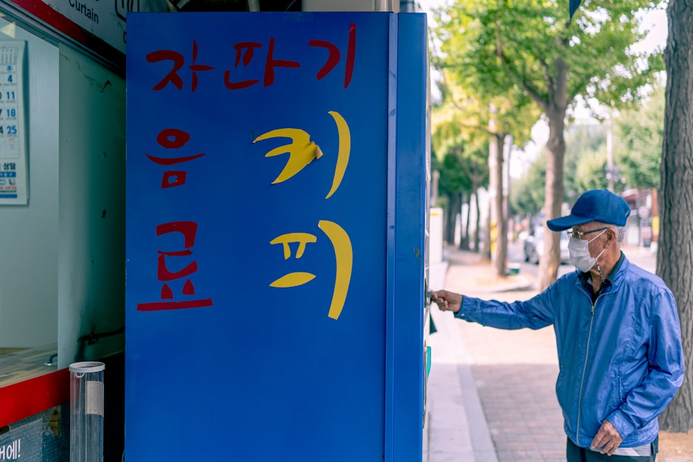 a man standing next to a blue sign