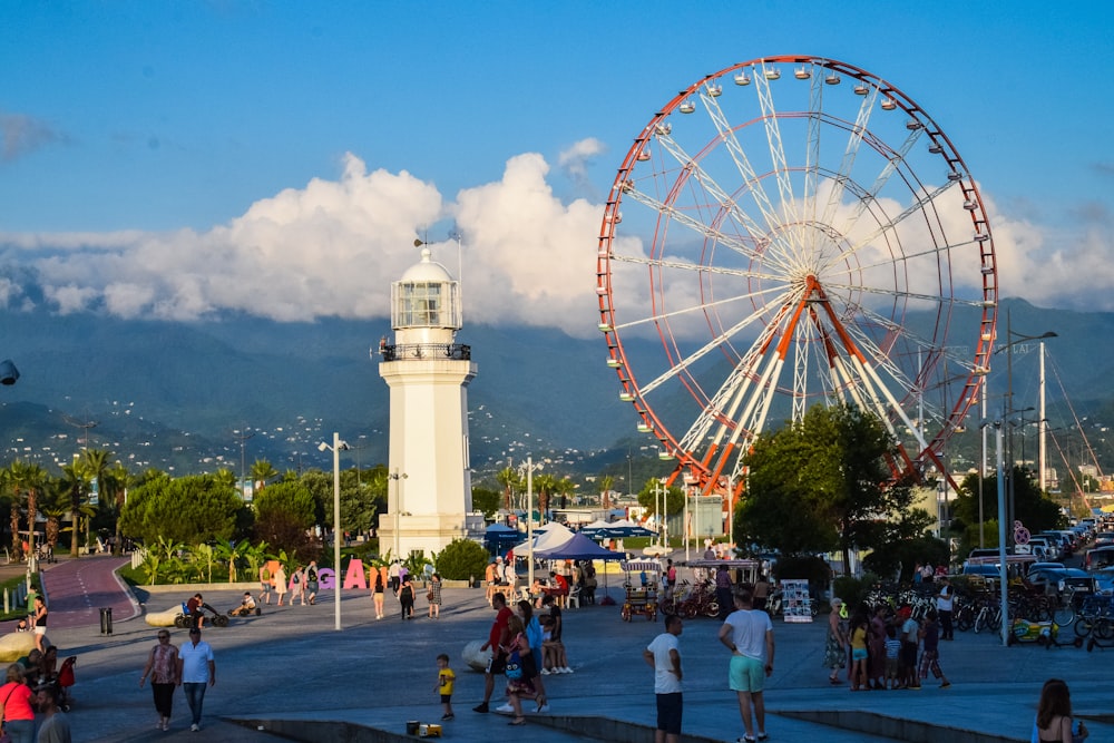 a group of people standing around a ferris wheel