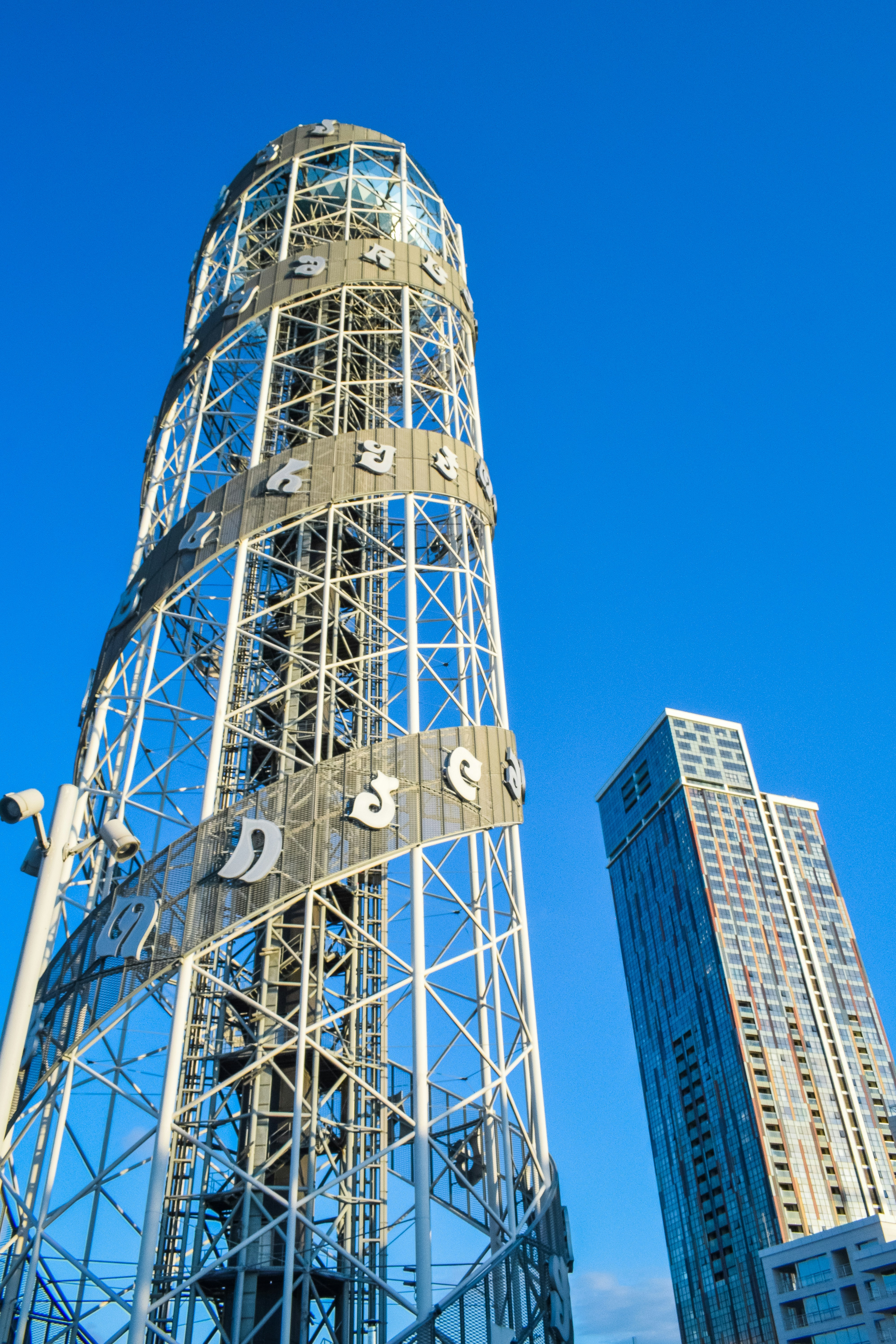 a tall metal tower with a clock on it's side