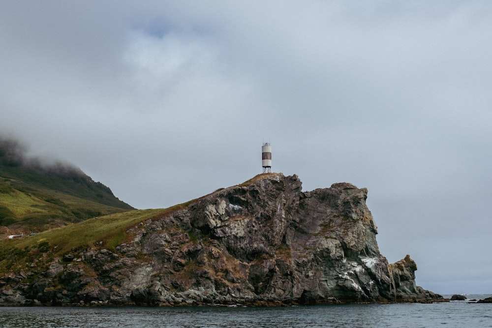 a lighthouse on top of a rock in the ocean