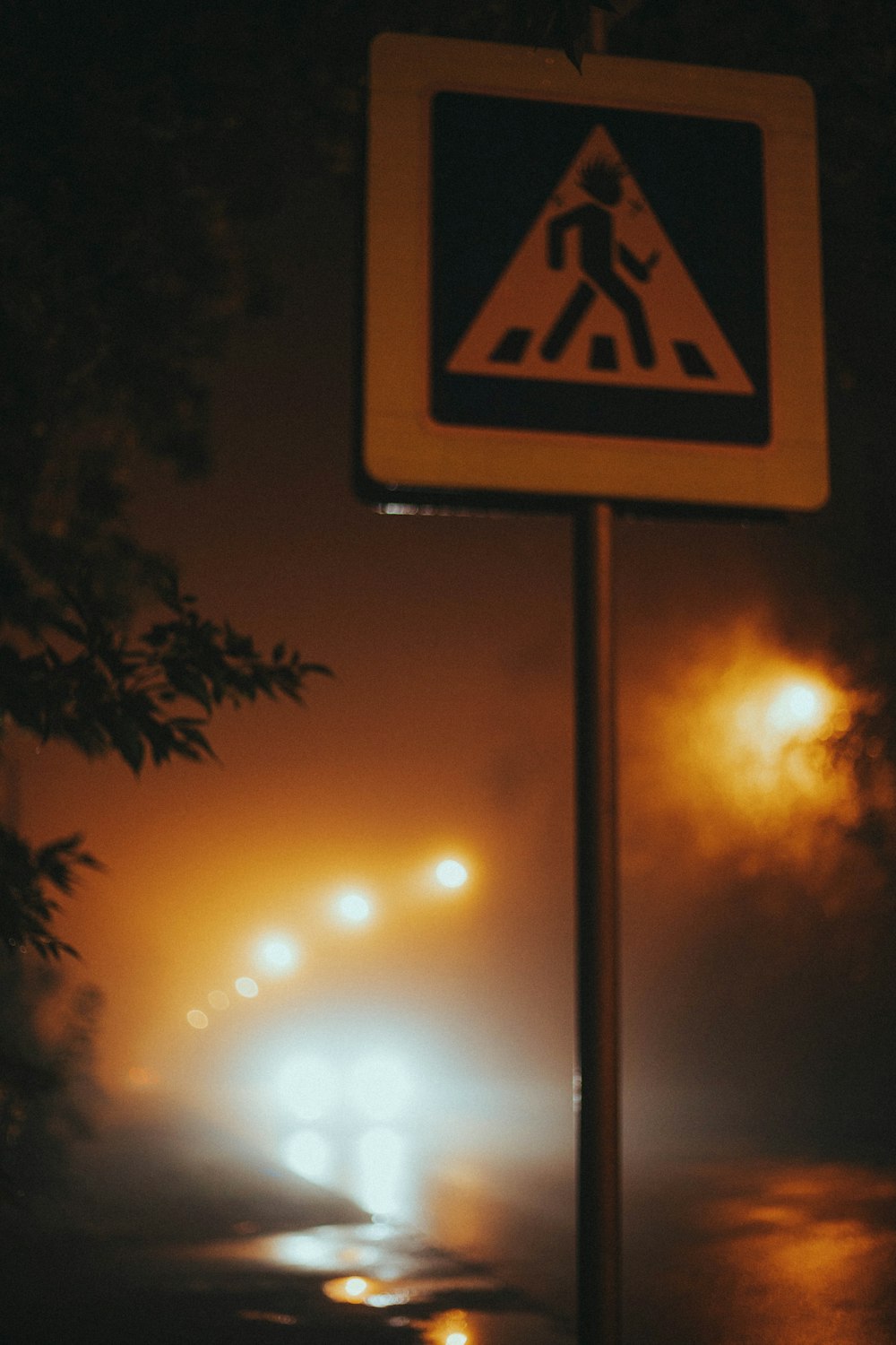 a street sign on a foggy street at night