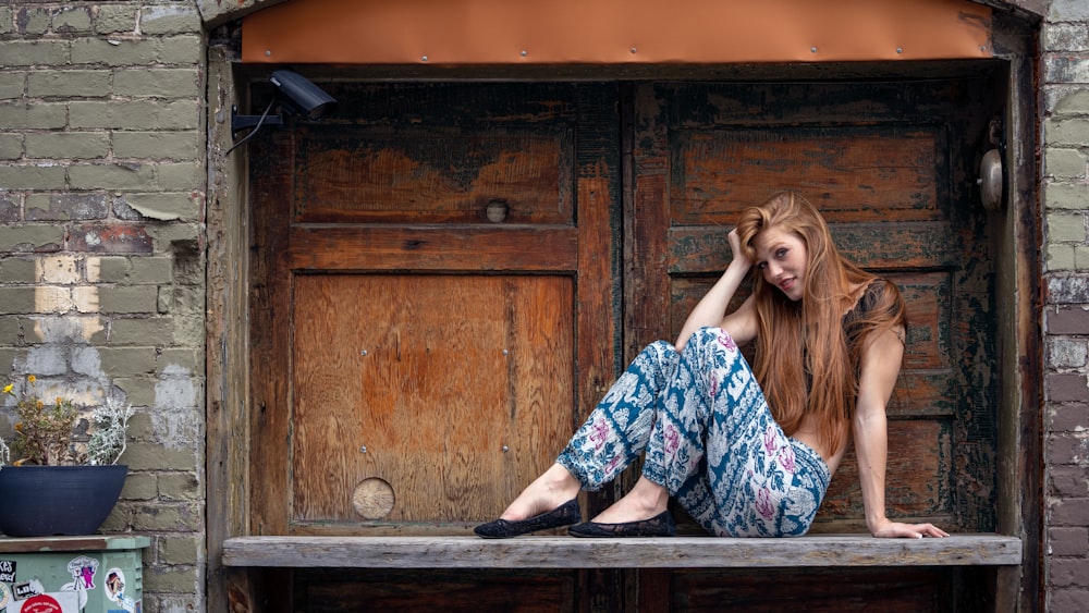 a beautiful young woman sitting on top of a wooden bench