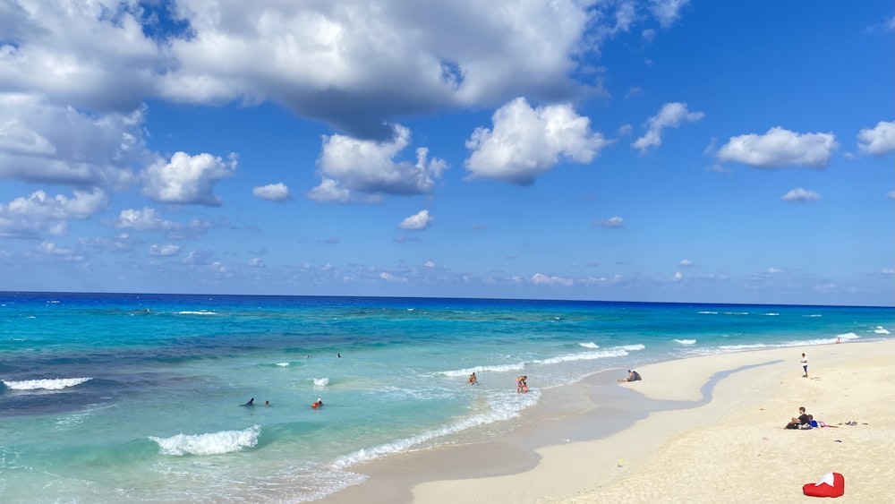 a group of people on a beach near the ocean