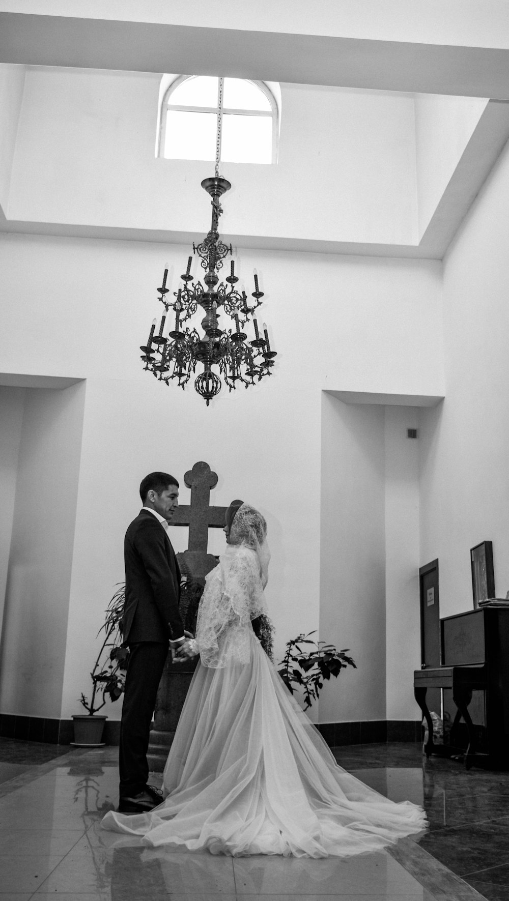 a bride and groom standing in front of a cross