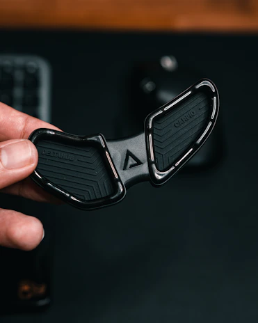 A hand holding the šviesulė product, highlighting its lightweight and ergonomic shape.