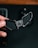 A hand is holding a black ergonomic object with a sleek design. The object has curved edges, and the text 'DELTAHUB' and 'CARPIO' are visible on its surface. The background is dark, providing contrast to the object being held.