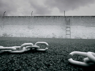 a chain is laying on the ground in front of a wall